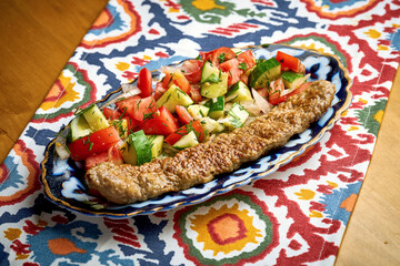 Traditional Turkish lyula kebab made of minced meat served on a plate with salad