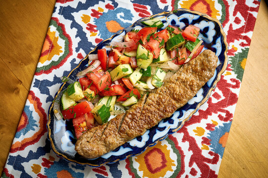 Traditional Turkish lyula kebab made of minced meat served on a plate with salad