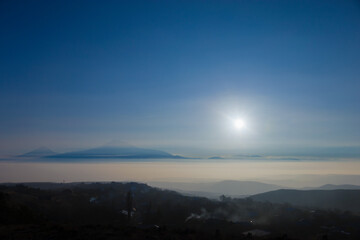 Fototapeta premium Mount Ararat and the setting sun on a foggy winter day