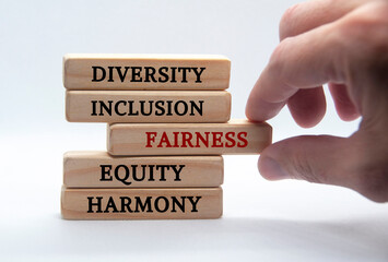 Diversity, inclusion, fairness, equity and harmony text on wooden blocks with white background....