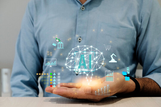 Businessman holding the brain and display virtual screen artificial intelligence (AI) to manage business processes through various icons, and artificial intelligence concepts.
