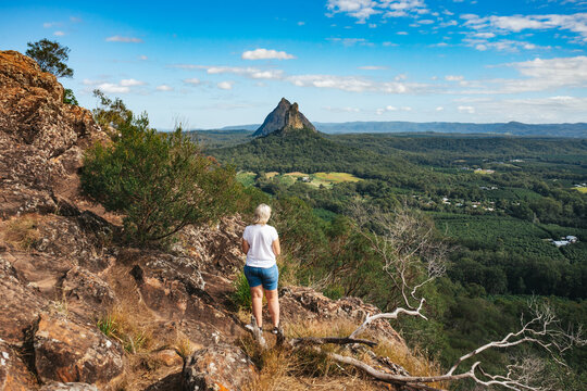 Woman looking out at the view from Mt Ngungun in the Glass House Mountains on the Sunshine Coast, Australia