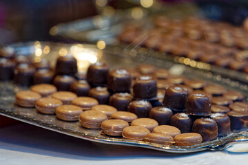 Close-up of different kinds of brown Swiss pralines on tablet at shop window. Photo taken January 13th, 2023, Zurich, Switzerland.