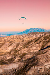Mountain desert and paragliding at sunset