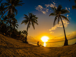 Fototapeta na wymiar Woman on sunny, tropical beach at daybreak 