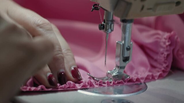 Close up working on sewing machine stitching side of fabric on a sewing machine