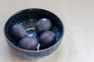 Blue easter eggs in a bowl. Painted eggs in hibiscus flowers