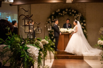 결혼식을 올리는 젊은 남여의 아웃포커스 된 결혼식장 풍경