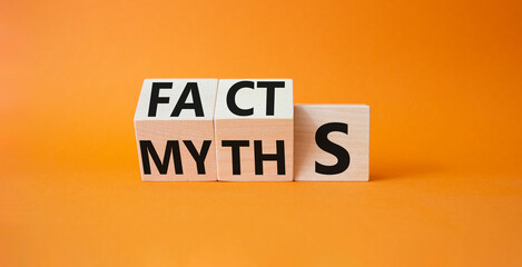 Facts vs Myths symbol. Wooden cubes with words Myths and Facts. Beautiful orange background....