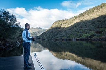 Pescador à margem do rio Tua à pesca. Entre montanhas, o rio Tua e o pescador com a sua cana à pesca