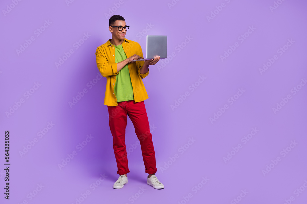 Poster full size portrait of positive smart man use wireless netbook coworking empty space isolated on purp