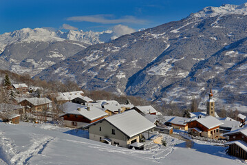 alpine village with snowy roofs in tarentaise valley view on snowcapped mountains under