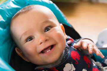 Smiling baby in a child chair