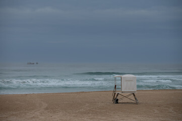 Fototapeta na wymiar Empty beach with lifesavers hut seen on shore