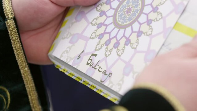 Mullah reviews amazing invitation to cultural city. Man holds invitation in envelope to tourists to visit mosque in ancient city closeup
