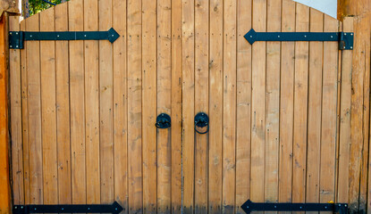 Large wooden gates made of light boards.
