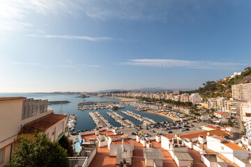 Paisaje marino de la costa brava con la imagen del puerto del pueblo de Blanes con sus edificios a un lado.