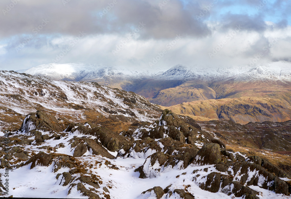 Wall mural The summits of Helvellyn, Nethermost and Dolly Wagon capped in snow and cloud from Pavey Ark in the Cumbrian Lake District Mountains, England UK.