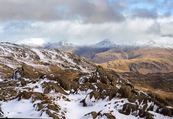 The summits of Helvellyn, Nethermost and Dolly Wagon capped in snow and cloud from Pavey Ark in the Cumbrian Lake District Mountains, England UK.