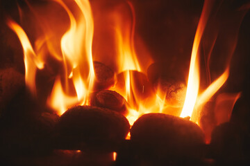 A close up of fire and flames coming from smokeless fuel buring in a stove providing warmth and...