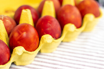 step by step how to diy at home easter chicken eggs with natural colorant.remove onion shell boil in water with eggs.red orange natural organic bio paint in cardboard holder glass bowl spring flowers