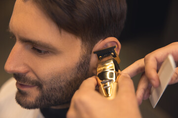 Barber carefully trimming the clients hair