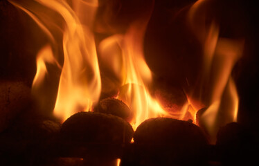 A close up of fire and flames coming from smokeless fuel buring in a stove providing warmth and...