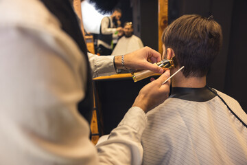 Barber carefully trimming the clients hair