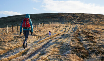 A hiker and their dog at Windy Rig below the summit of Windy Gyle on a sunny but frosty winters...