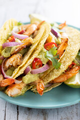 Mexican tacos with shrimp,guacamole and vegetables on wooden table
