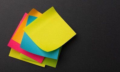A stack of office stickers in bright colors on a gray table.