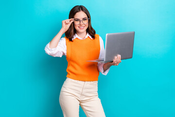 Photo of young professional code developer lady touch glasses wear orange vest shirt hold laptop project manager isolated on blue color background - obrazy, fototapety, plakaty