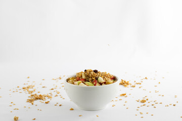 Chopped tropical and juicy fruits, granola, symbolizing healthy life, on white background