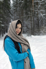 A beautiful young woman enjoys the snow in the forest.