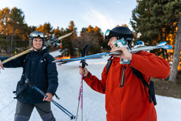 Two boys talking with ski equipment in the snow.