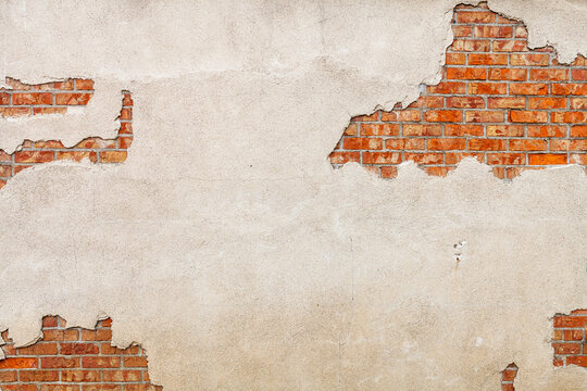 Fototapeta Cracked facade with visible bricks as a background