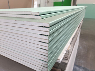 water resistant plasterboard sheets stacked in a hardware store. dry gypsum plaster. building material for the arrangement of cladding, partitions, ceilings in buildings. - obrazy, fototapety, plakaty