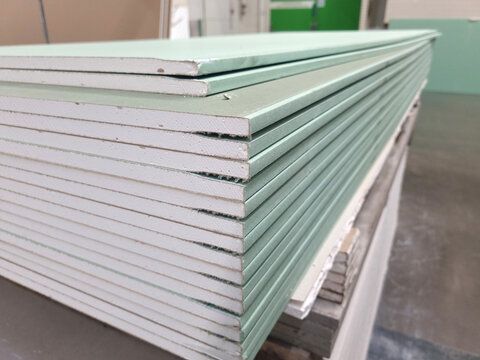 water resistant plasterboard sheets stacked in a hardware store. dry gypsum plaster. building material for the arrangement of cladding, partitions, ceilings in buildings.