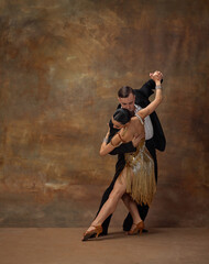Femininity and masculinity. Man and woman, professional tango dancers in stylish, beautiful stage...