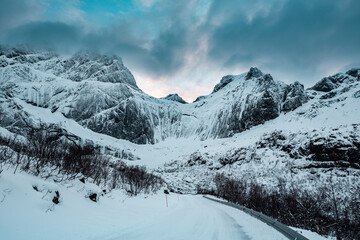 Fototapeta premium Sunny winter day in Reine, fishing village in Norway, drone shot on amazing landscape in Lofoten. Lovely clouds and blue sky.