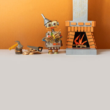 A toy robot with a bundle of firewood stands near the fireplace chimney, mantle. Brown wall gray floor background. brown gray background, copy space