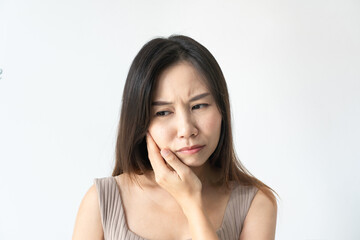 Fototapeta premium Young Asian woman feeling teeth pain. Close up of sad girl suffering from toothache on white background. Dental health and care, teeth problem concept. Copy space, closeup