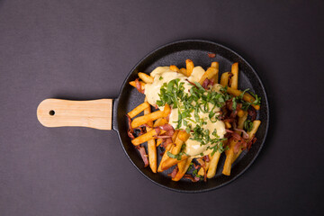 with fried bacon on a black tray on a dark background