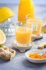 Homemade turmeric lemon ginger shots in small glasses