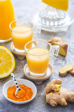 Homemade turmeric lemon ginger shots in small glasses