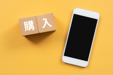 購入と書かれたブロックとスマホ