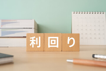利回りと書かれたブロックが置かれたデスク