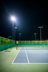 야간 경기를 위해 불빛이 켜진 야외 테니스장