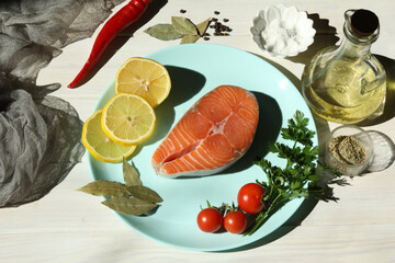 Fresh salmon steak with ingredients on dark wooden background