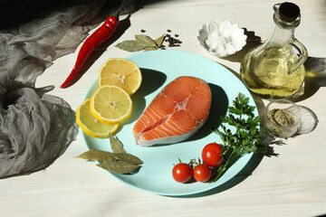 Fresh salmon steak with ingredients on dark wooden background